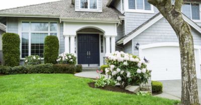 White Cream house with green grass front photo